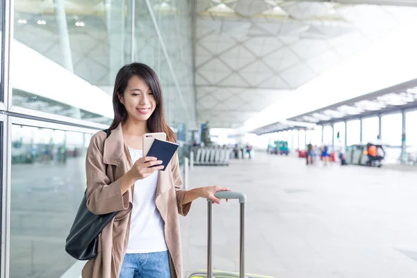 空港で彼女の荷物を持って携帯電話をしている女の人 — ストック写真