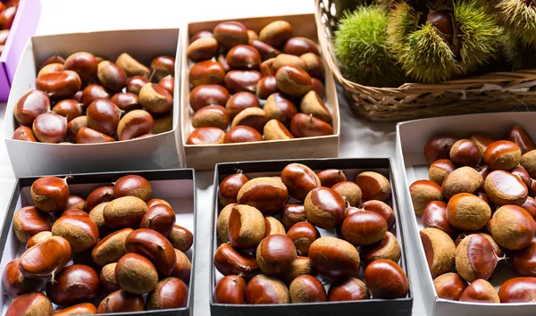 Castanhas frescas em caixas na mesa — Fotografia de Stock