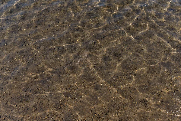 Su dalgalar su birikintisi üzerinde — Stok fotoğraf