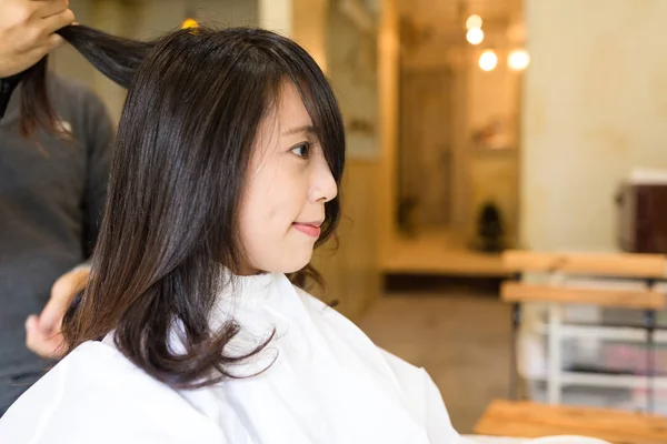 Woman having haircut in salon