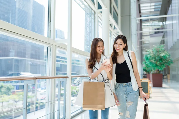 Vänner gå shopping och med hjälp av mobiltelefon — Stockfoto