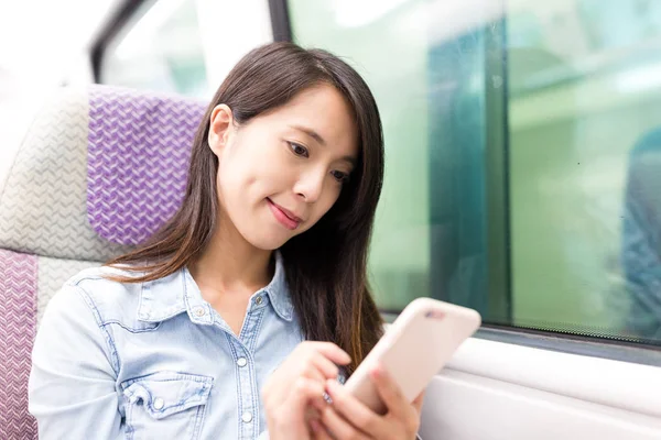 Женщина с сотовым телефоном и поездом — стоковое фото