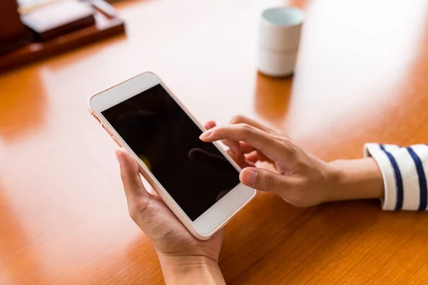 Палец с помощью мобильного телефона в ресторане — стоковое фото