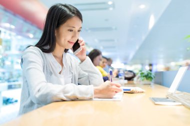 Not üzerinde yazma ve telefonda konuşurken kadın