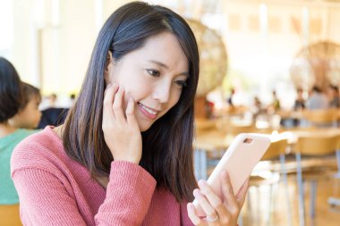 Restoranda cep telefonu kullanan kadın