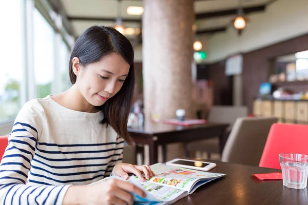 Жінка читає журнал в кав'ярні — стокове фото