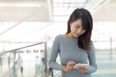 Havaalanında cep telefonu üzerinde çalışan kadın