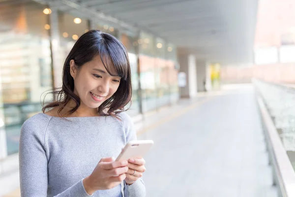 Mladá žena pomocí mobilního telefonu — Stock fotografie