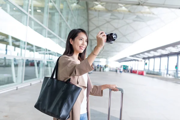 女性が空港でカメラで写真を撮影 — ストック写真