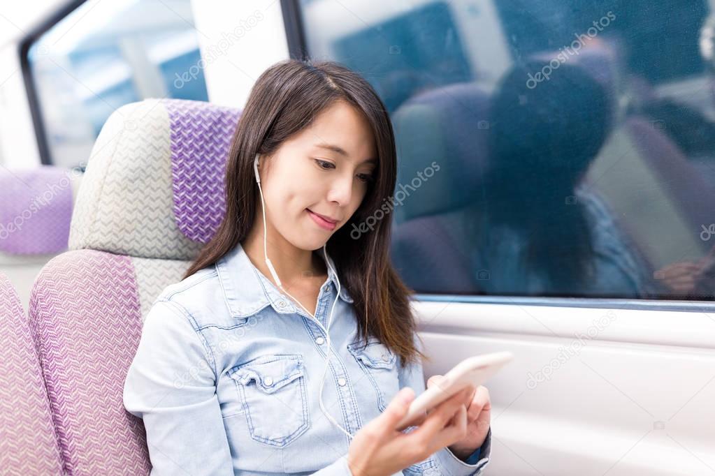 Woman listen to music from mobile phone