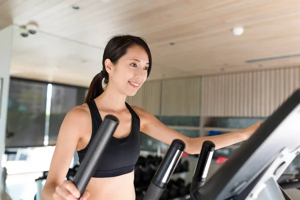 Woman training on Elliptical machine in gym — Stock Photo, Image