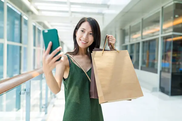 Frau hält Einkaufstüten in der Hand und macht Selfie — Stockfoto