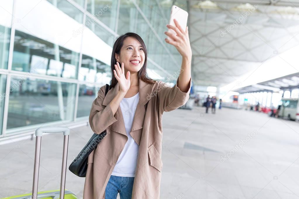 woman taking selfie by smartphone in airport