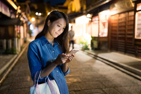 Mulher procurando no celular à noite — Fotografia de Stock