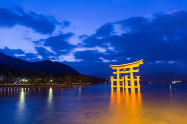 Torii in Itsukushima shine during sunset clipart