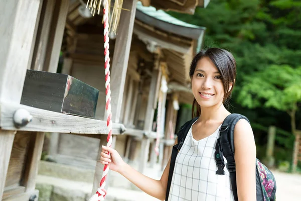 Mulher tocando a campainha no templo japonês — Fotografia de Stock