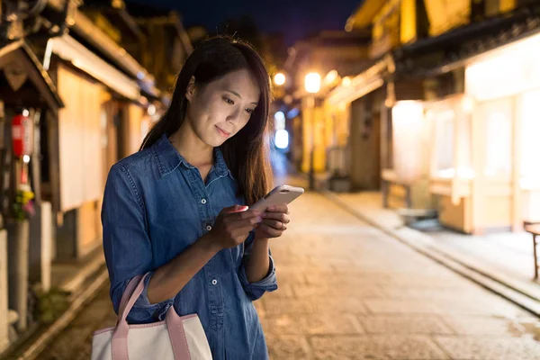 Жінка використовує мобільний телефон вночі — стокове фото