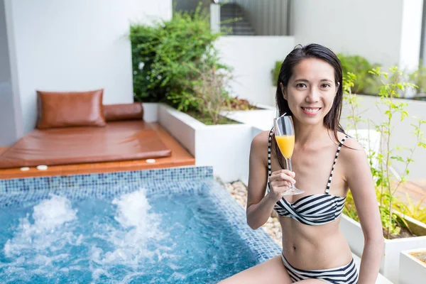 Женщина наслаждается джакузи spa и пить — стоковое фото