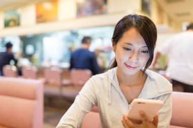 Cep telefonu bir restoranda bakarak kadın