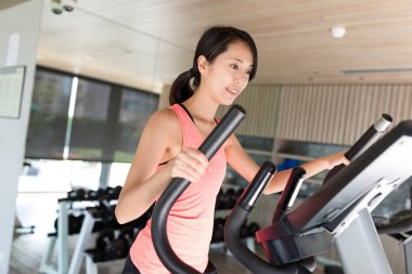 Spor salonunda eliptik makinede eğitim kadın