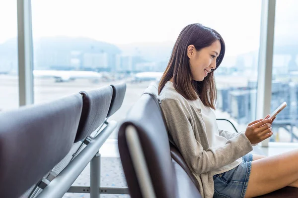 Жінка працює на мобільному телефоні в аеропорту — стокове фото