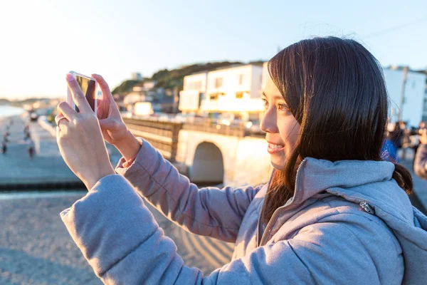 Kvinnan tar foto i Kamakura seaside — Stockfoto