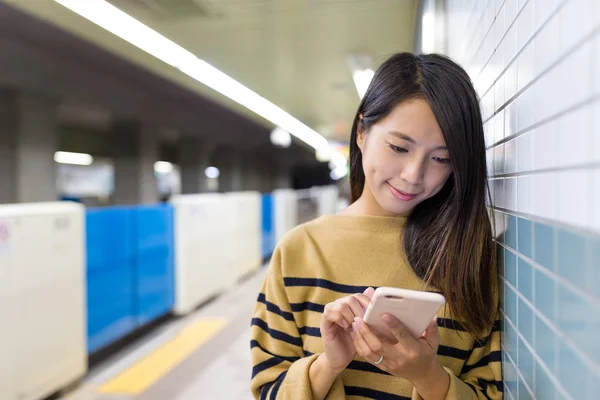 Woman using cellphone in metro — Stock Photo, Image