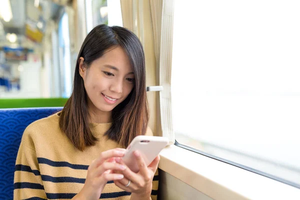 Žena používající mobilní telefon ve vlaku — Stock fotografie