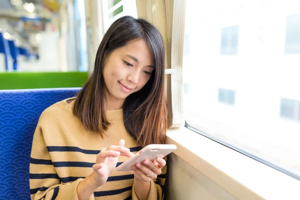 Woman using cellphone for online on train — Stock Photo, Image