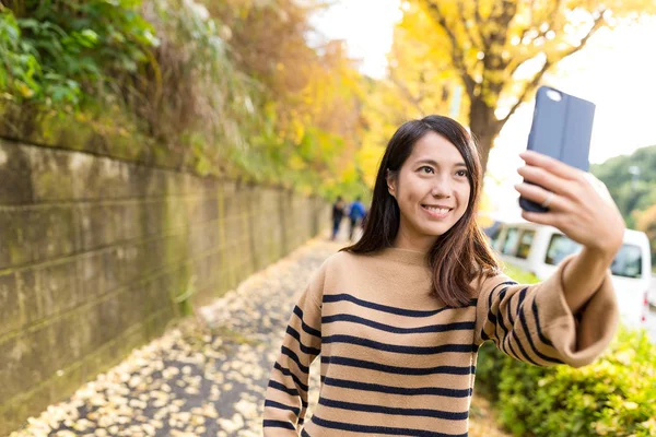 Vrouw die selfie met cellphone in de weg — Stockfoto