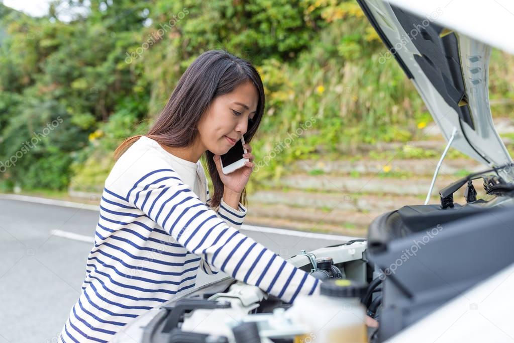 Woman calling others with repairing the car
