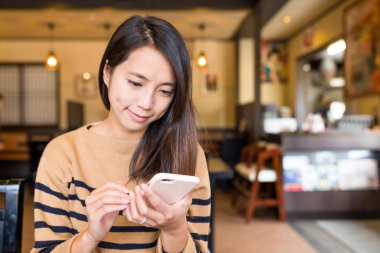 restoranda cep telefonu kullanan kadın