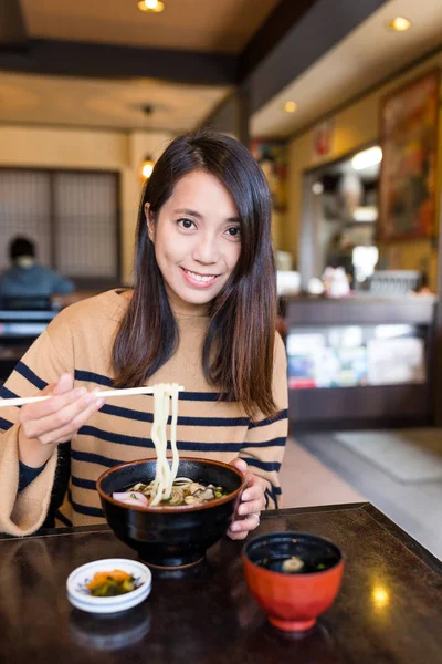 Mulher tendo udon no restaurante japonês — Fotografia de Stock