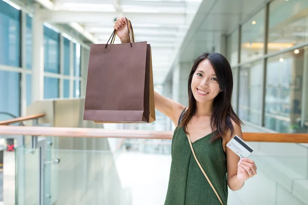 Kvinna som innehar shoppingväskor och kreditkort — Stockfoto