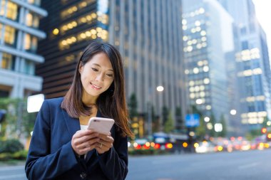 İş kadını cep telefonu kullanıyor.