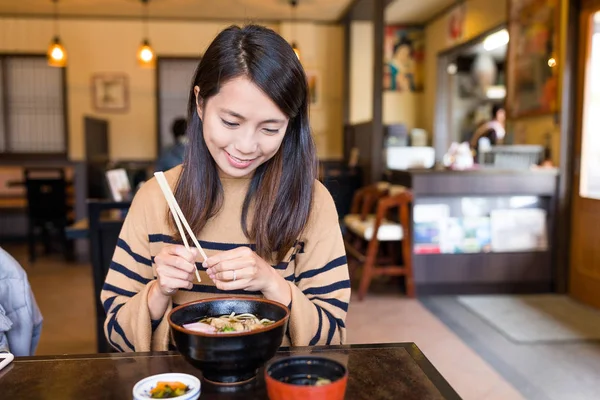Жінка насолоджується японським раменом в ресторані — стокове фото