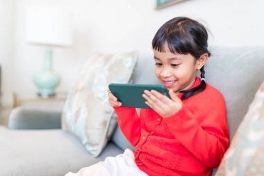 Cep telefonu kullanan küçük kız.