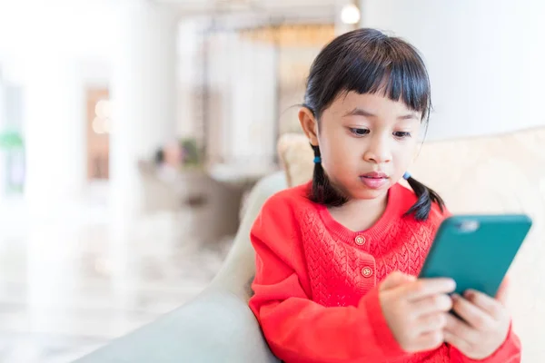 Маленькая девочка с помощью мобильного телефона — стоковое фото