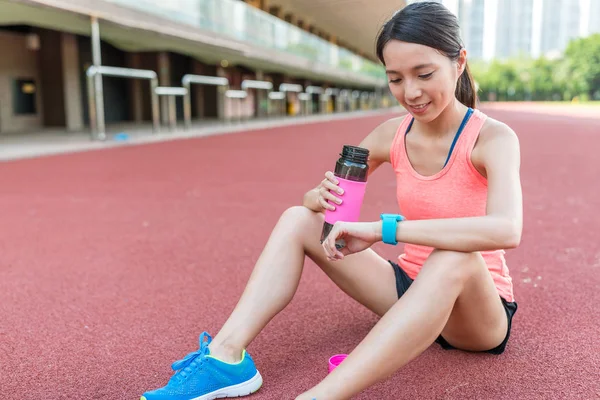 Woman using smart watch and drink of water