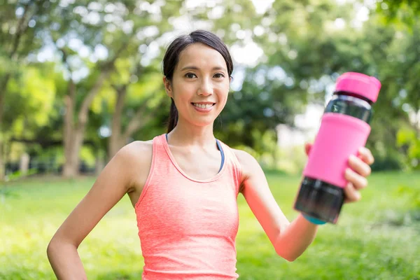 Frau hält Wasserflasche im Park — Stockfoto