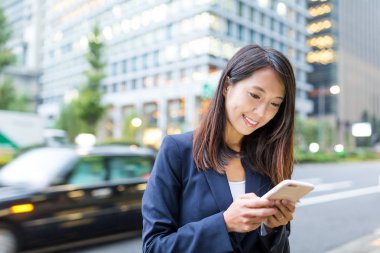 İş kadını cep telefonu kullanıyor.