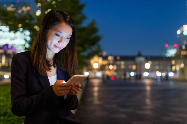 Empresária trabalhando no telefone celular à noite — Fotografia de Stock