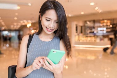Alışveriş merkezinde cep telefonu arayan kadın