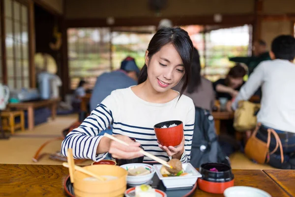 Mujer comiendo comida japonesa en el restaurante —  Fotos de Stock