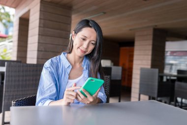 Kafede akıllı telefon kullanan bir kadın.