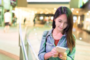 Şehirde akıllı telefon kullanan bir kadın.