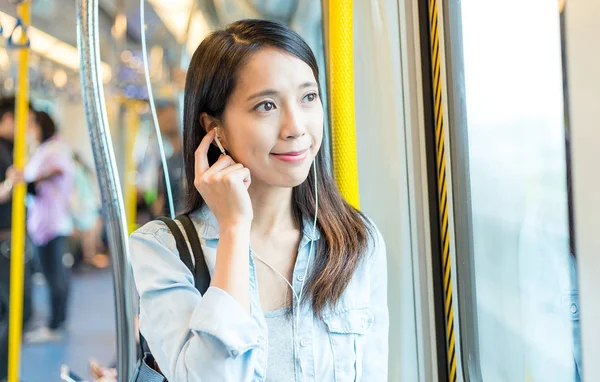 Woman listen to music on phone on train