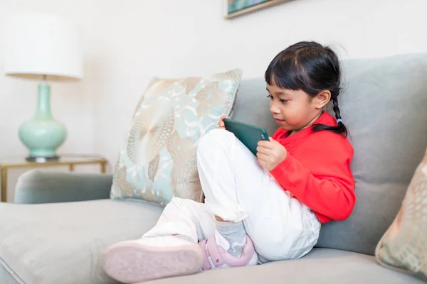 Petite fille regardant le téléphone portable à la maison — Photo