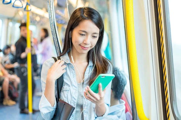 Vrouw luister naar liedje op telefoon in de trein — Stockfoto