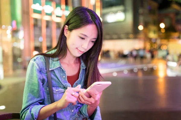 Mulher usando smartphone na cidade à noite — Fotografia de Stock